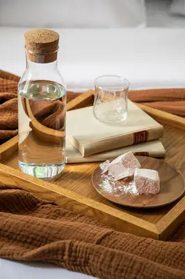 a wooden tray with a bottle and a plate with a glass at Monsieur Didot in Athens