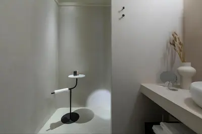 a white bathroom with a sink and a toilet paper holder at Monsieur Didot in Athens