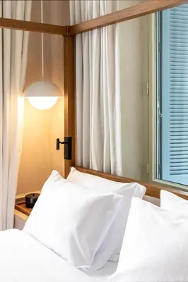 a bedroom with a bed with white sheets and a window at Monsieur Didot in Athens