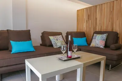 a living room with two couches and a table with wine glasses at V36 Suites in Athens