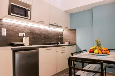 a kitchen with a table with a bowl of fruit at V36 Suites in Athens