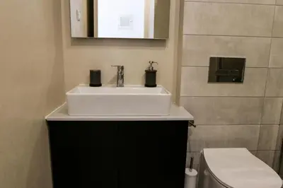 a bathroom with a white sink and a toilet at V36 Suites in Athens