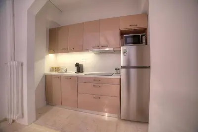 a kitchen with a stainless steel refrigerator and cabinets at L'appartement blanc dans le centre de Glyfada in Athens