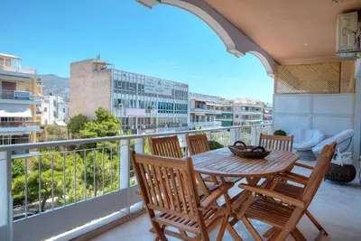 a table and chairs on a balcony with a view at L'appartement blanc dans le centre de Glyfada in Athens
