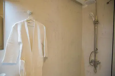 a white sweater on a hanger in a shower at L'appartement blanc dans le centre de Glyfada in Athens