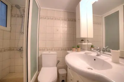 a white bathroom with a toilet and a sink at L'appartement blanc dans le centre de Glyfada in Athens