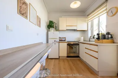 a kitchen with white cabinets and a counter top at Nesto Athens Airport in Spáta