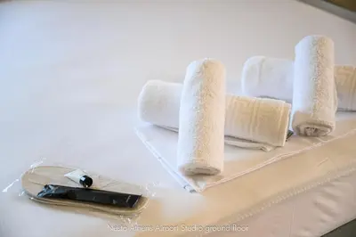 a white table with towels and a bottle of champagne at Nesto Athens Airport in Spáta