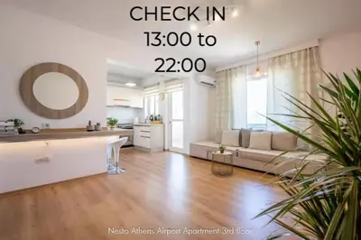 a large living room with a couch and a kitchen at Nesto Athens Airport in Spáta