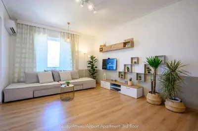 a living room with a couch and some plants at Nesto Athens Airport in Spáta