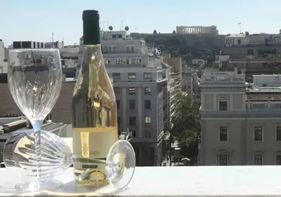 a bottle of wine and a wine glass on a ledge at Amazing Apartments @ Aiolou Str. in Athens