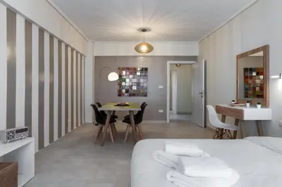 a bedroom with a bed and a table and chairs at Amazing Apartments @ Aiolou Str. in Athens