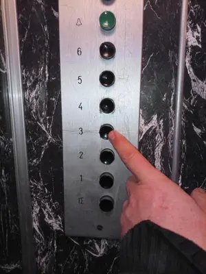 a hand is pressing a button on a control panel at Cozy studio near Victoria metro station in Athens