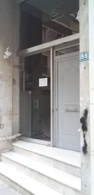 a building with a white door and a window at Cozy studio near Victoria metro station in Athens