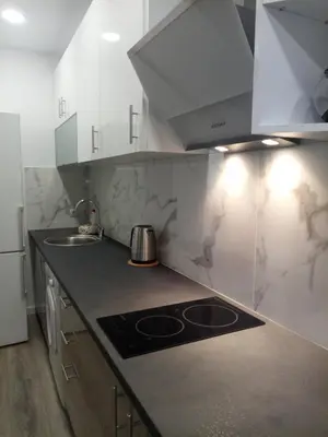 a kitchen with white cabinets and a stove top oven at Cozy studio near Victoria metro station in Athens