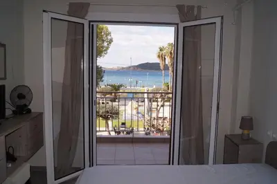 a bedroom with a bed and a view of the ocean at Sea Side Apartment in Palaiá Fókaia