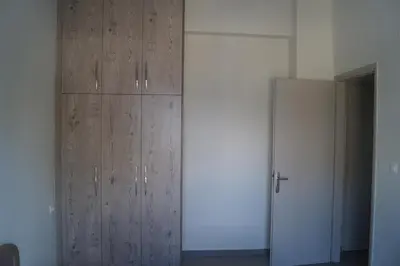 a wooden cabinet in a room with a refrigerator at Sea Side Apartment in Palaiá Fókaia