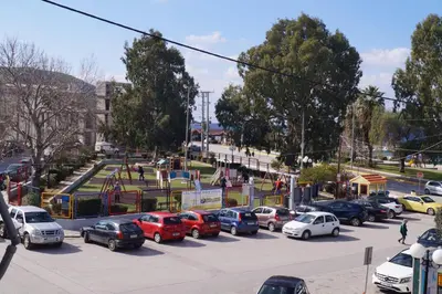 a group of cars parked in a parking lot at Sea Side Apartment in Palaiá Fókaia