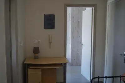 a room with a desk and a door to a hallway at Sea Side Apartment in Palaiá Fókaia