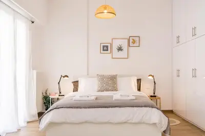 a white bedroom with a large bed with white walls at Wide Comfy Studio Apartment Centrally Located In Thissio in Athens