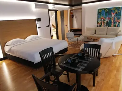 a bedroom with a bed and a couch and a table at Andromeda Downtown Residence in Athens