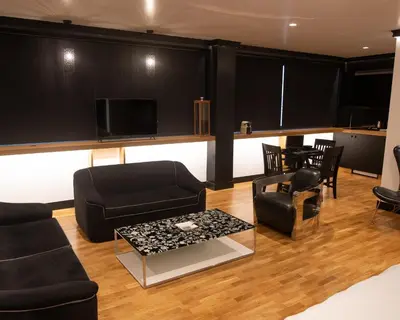 a living room with black furniture and a flat screen tv at Andromeda Downtown Residence in Athens
