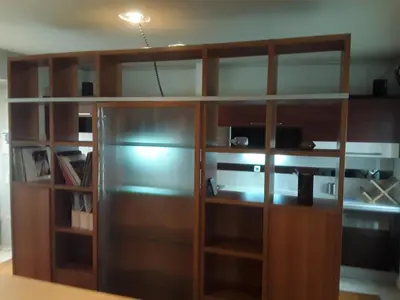 a wooden book shelf with a refrigerator in a room at Deluxe Apartment Best Point in Athens
