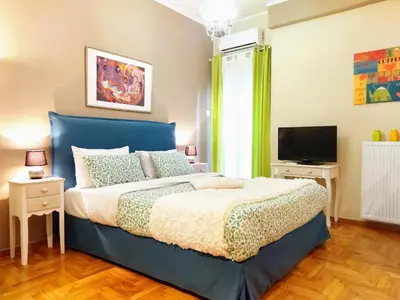 a bedroom with a blue bed and a television at City Stay Alexandras Av. in Athens