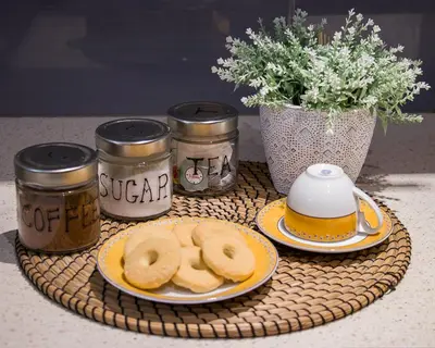 a table with a plate of donuts and jars of honey at City Stay Alexandras Av. in Athens