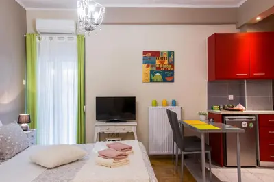 a kitchen with red cabinets and a table with a dining room at City Stay Alexandras Av. in Athens