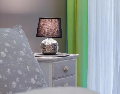 a lamp on a night stand next to a bed at City Stay Alexandras Av. in Athens