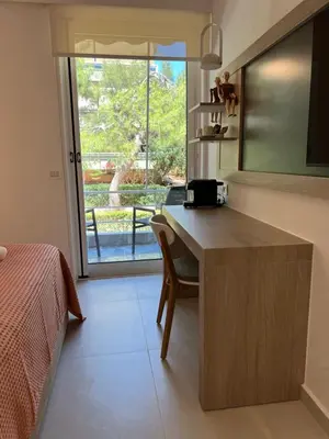 a bedroom with a desk and a bed and a window at Fospitality Varkiza in Varkiza