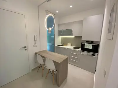 a kitchen with a wooden table and two chairs at Fospitality Varkiza in Varkiza