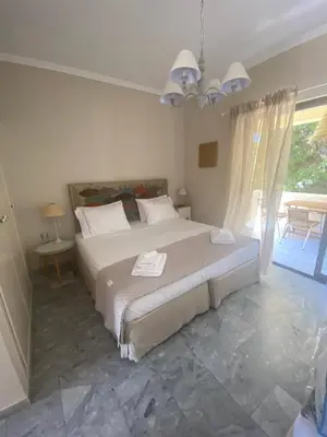 a bedroom with a large bed and a patio at Aelia Houses in Agia Marina Aegina