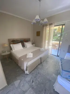a bedroom with a large bed and a large window at Aelia Houses in Agia Marina Aegina
