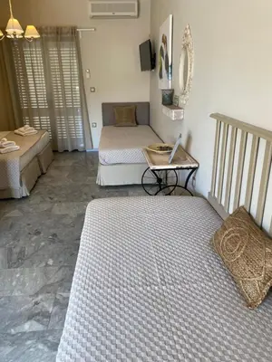 a living room with two beds and a table at Aelia Houses in Agia Marina Aegina