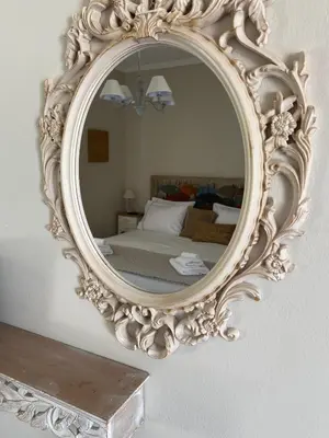 an ornate mirror on a wall in a bedroom at Aelia Houses in Agia Marina Aegina