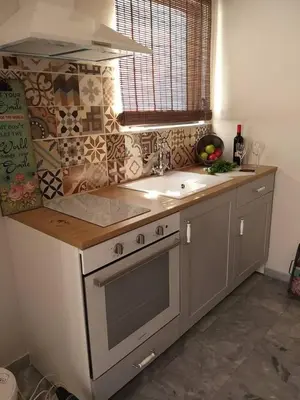 a kitchen with a stove and a sink and a window at Aelia Houses in Agia Marina Aegina