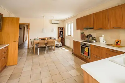 a kitchen with a table and a dining room at Family getaway, spacious and luxurious, sea view, terrace, 5 minutes from Voula beach, 30min from Athens center in Athens