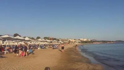 a group of people on a beach with umbrellas at Family getaway, spacious and luxurious, sea view, terrace, 5 minutes from Voula beach, 30min from Athens center in Athens