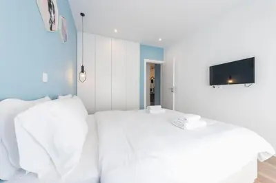 a bedroom with two white beds and a flat screen tv at 3 mins walking from Acropolis in Athens