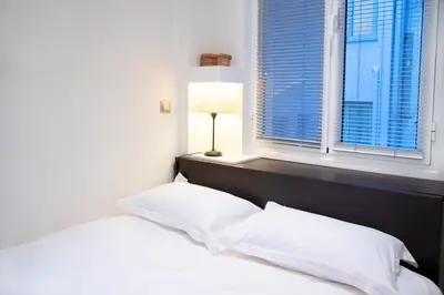 a bedroom with a bed with white sheets and a window at Athens Best location, 6 Ermou street, Syntagma square in Athens