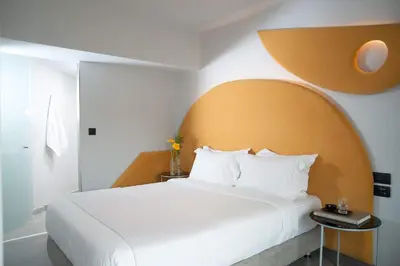 a bedroom with a large white bed with a large orange headboard at Athens Utopia Ermou in Athens
