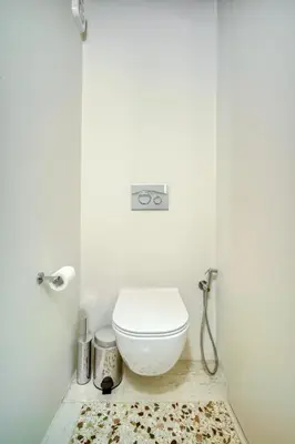 a bathroom with a white toilet and a rug at KERAMOS Athens in Athens