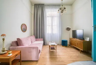 a living room with a pink couch and a tv at KERAMOS Athens in Athens