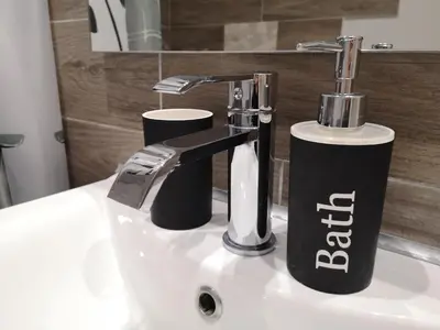 a bathroom sink with a soap dispenser on it at Sea&Sun Glyfada Apartment in Athens