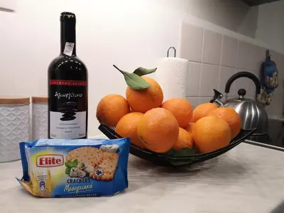 a bowl of oranges on a counter next to a bottle of wine at Sea&Sun Glyfada Apartment in Athens
