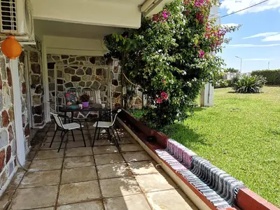 a patio with a table and chairs in a garden at Sea&Sun Glyfada Apartment in Athens