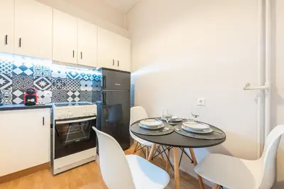 a kitchen with a table and chairs in a room at Gorgeous & Modern At Ampelokipi Metro Station By Greece Apartments in Athens