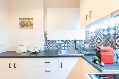 a kitchen with white cabinets and blue and white tiles at Gorgeous & Modern At Ampelokipi Metro Station By Greece Apartments in Athens